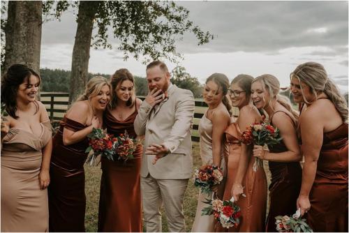 bridesmaids holding burnt orange and burgundy bouquets