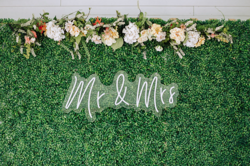 greenery photo backdrop wall with neon sign