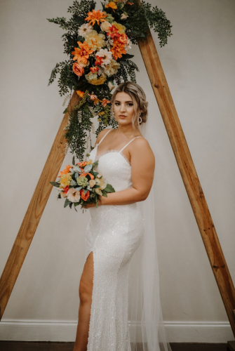 bride in front of triangle wedding arch