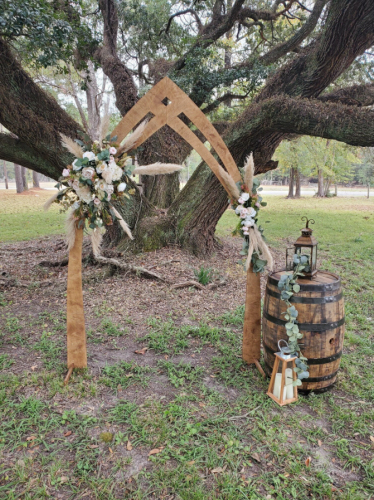 outdoor wooden wedding arch with whiskey barrel