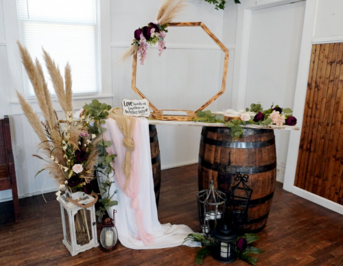 whiskey barrel table with pampas grass and lanterns