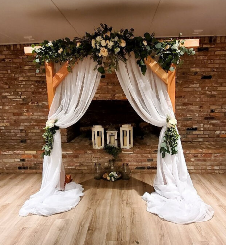 wooden wedding arch with white drapery